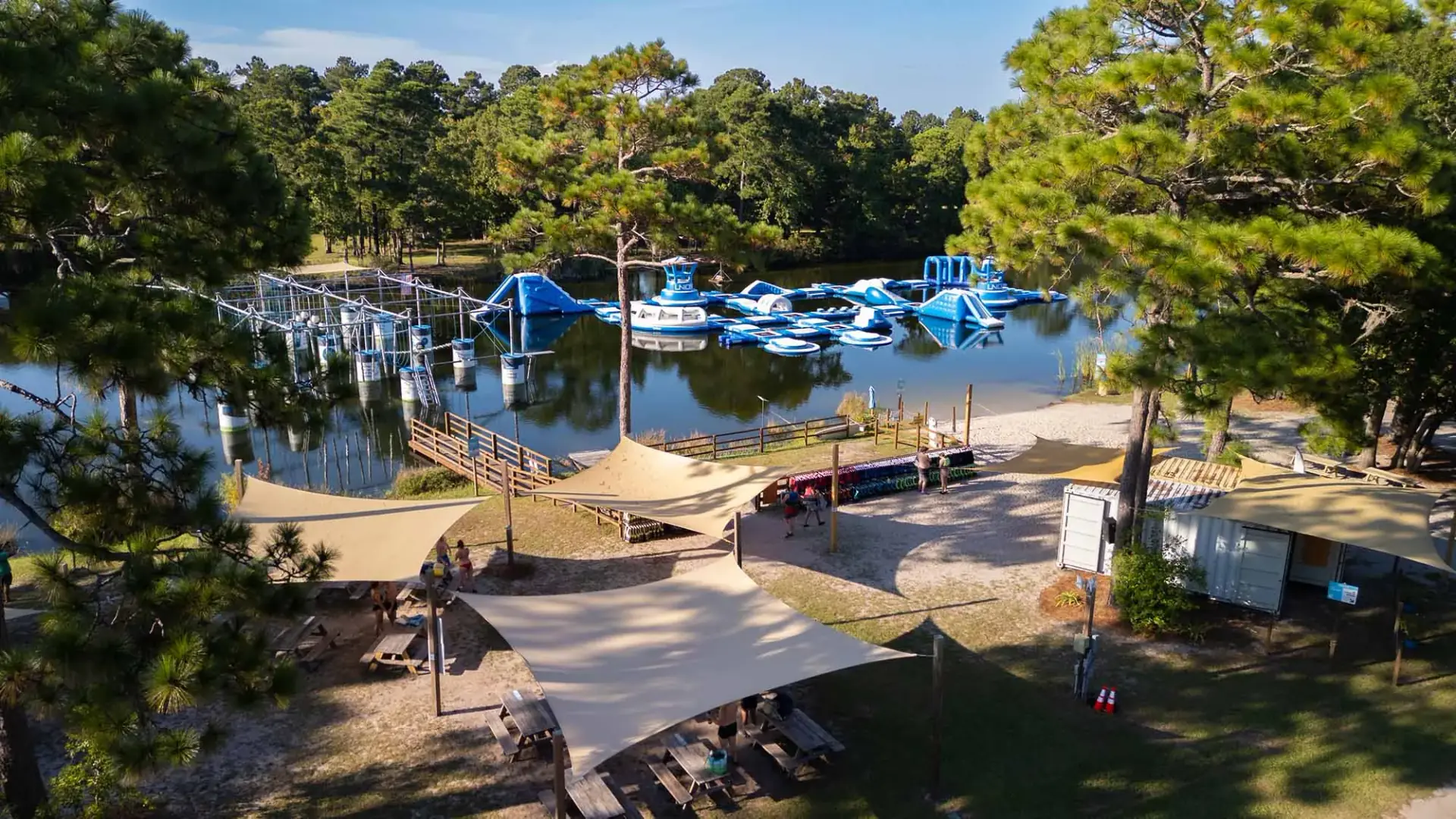 Kids jumping and climbing on the floating inflatable obstacle course at Charleston Aqua Park water park Johns Island SC